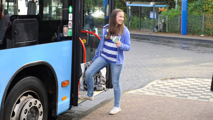 Schülerin steigt in einen blauen WSW Bus