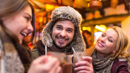 Ein Mann und zwei Frauen trinken heiße Schokolade