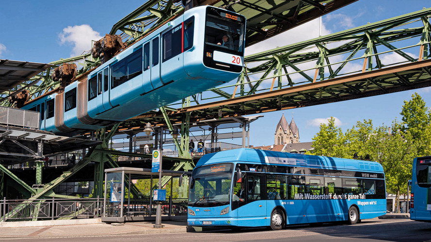 Unter der Schwebebahn fährt ein Bus auf der Straße